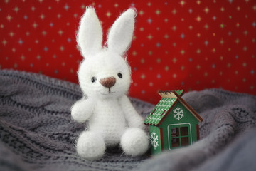 Small bunny toy and decorative house on blanket