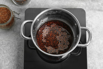 Stewpot with raw rice and water in kitchen