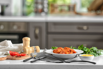 Plate with tasty sausage balls on kitchen table
