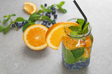 Mason jar of infused water with orange on table