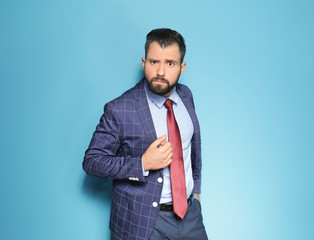 Handsome emotional businessman on color background
