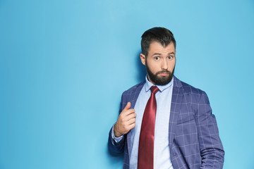 Handsome emotional businessman on color background