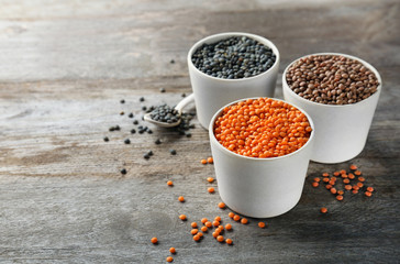 Bowls with different lentils on wooden table