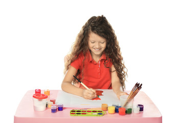 Little cute girl painting at table on white background