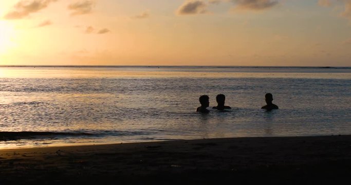 amis qui se baignent au coucher du soleil 