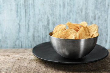 Bowl with potato chips on table