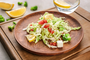 Plate with tasty vegetable salad on table