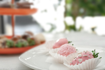 Plate with tasty glazed strawberries on table