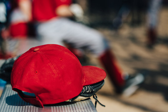 Red baseball cap on a bench at a game