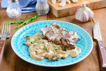 Plate with steak Diane on table