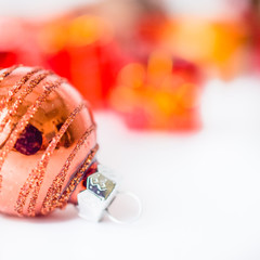 Close-up of xmas ball with blurred colorful Christmas decor in background. Christmas and New Year concept with copy space. Christmas greeting card.