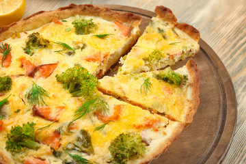 Tasty salmon quiche on wooden board