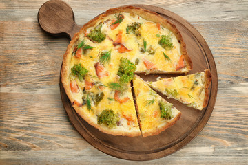 Tasty salmon quiche on wooden board