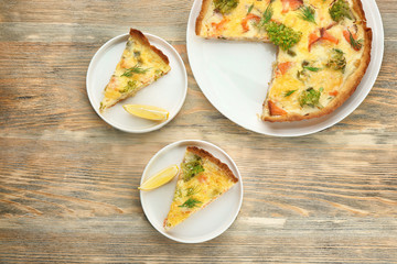 Tasty salmon quiche on table