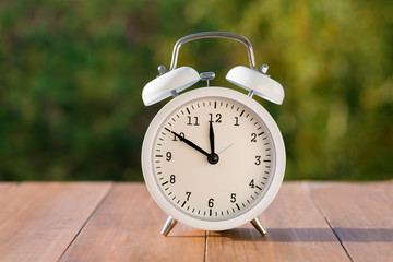 White vintage clock on natural background. Autumn time change