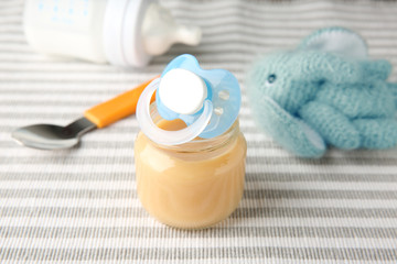 Jar of tasty baby food on cloth