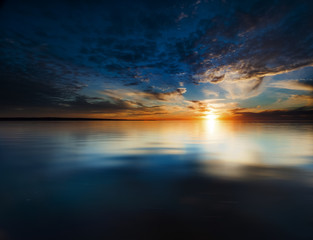 Fototapeta na wymiar Sunset reflections over a glassy ocean