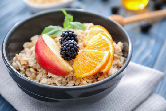 Tasty oatmeal with fruits in bowl on table