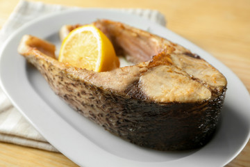 Ceramic plate with fried fish steak, closeup