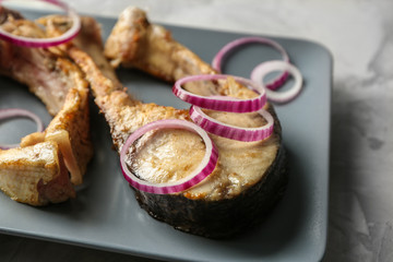 Ceramic plate with fried fish steaks, closeup