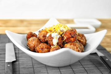 Plate with tasty sausage cheese balls on table