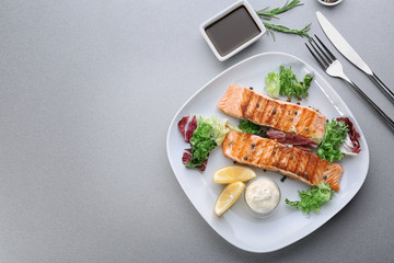 Plate with delicious slices of salmon on table
