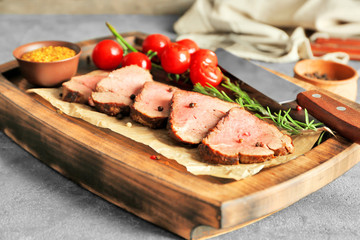 Sliced tasty steak on wooden board