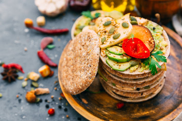 Variety of open sandwicheswith rye bread with different toppings over aged blue background