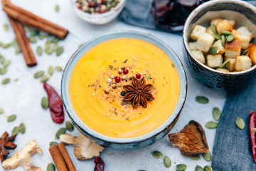 Bowl with carrot pumpkin soup and spices. Flat lay styling