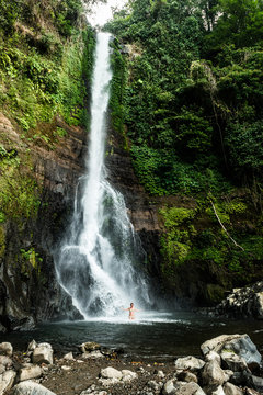 Girl swim in beautiful waterfall in the rain forest