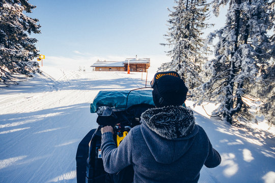 man driving snowmobile in snowcoverd austrian landscape