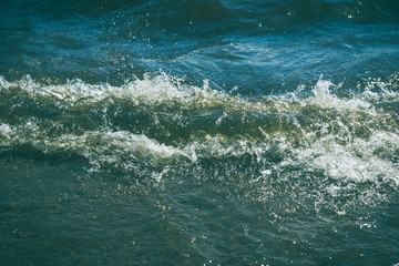 Obraz premium Small waves on the sea shore on a sunny day