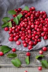 Fresh red cranberries with leaves on the table 