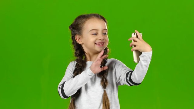 Child does selfie. Green screen
