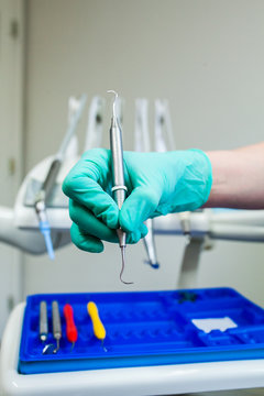 Hand holding a tool of a dental hygienist or dentist
