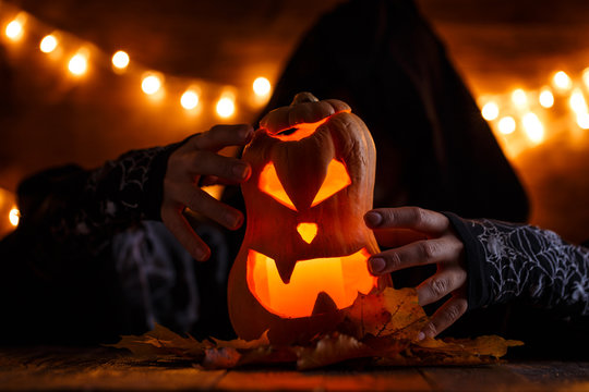 Photo of halloween pumpkin cut in shape of face with witch