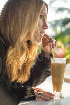 Woman Drinking Iced Coffee With A Straw