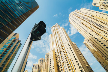 Low angle view of city buildings and traffic light. Dubai, United Arab Emirates