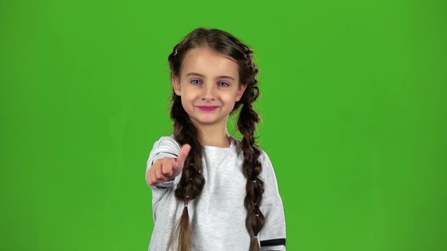 Baby girl shows thumbs up. Green screen. Slow motion