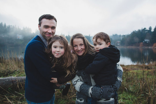 Fun portrait of happy family of four outide in west coast winter