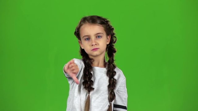 Child is showing the finger down. Green screen. Slow motion