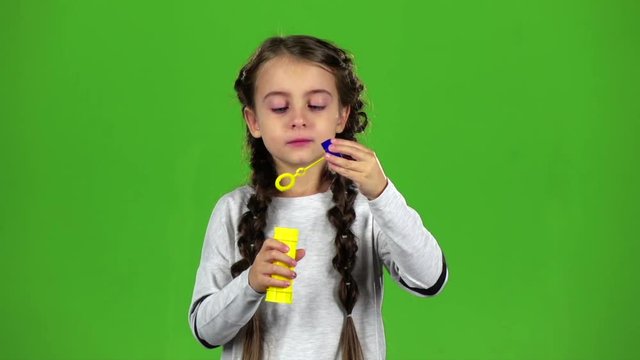 Child with soap bubbles. Green screen. Slow motion