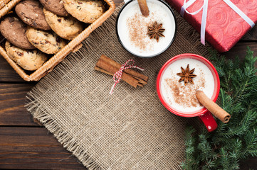 eggnog cocktail in  mug arranged with christmas decoration and cookies box on wooden table