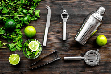 In the bar. Shake mojito. Lime, mint., barman tools on wooden background top view