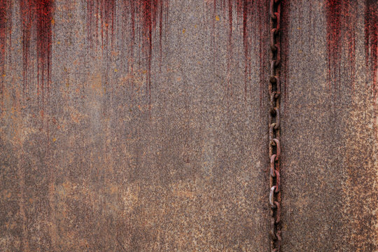 Bloody background scary old rusty chains hanging on rusted steel wall, concept of horror and Halloween