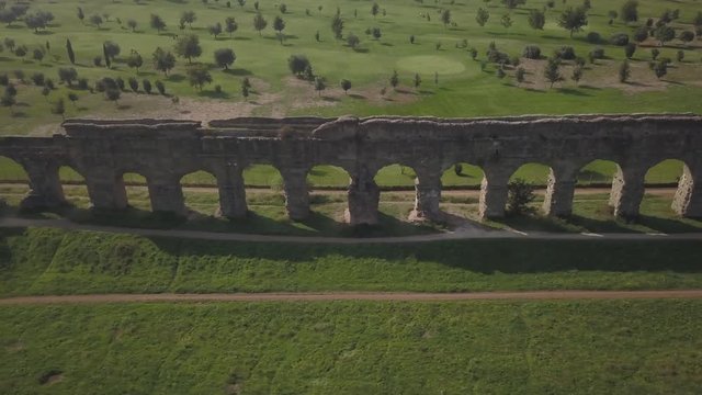 Video from above. Aerial view of the ancient Roman Aqueduct. Old ruins surrounded by a green public Park (Parco degli Acquedotti) Rome, Italy.	