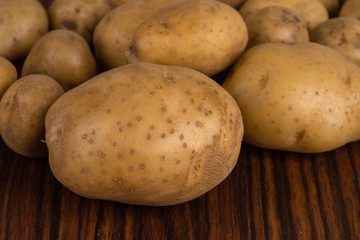 Raw potatoes on wooden table