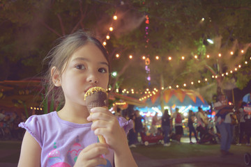 little girl having ice cream at state fair, filtered tones