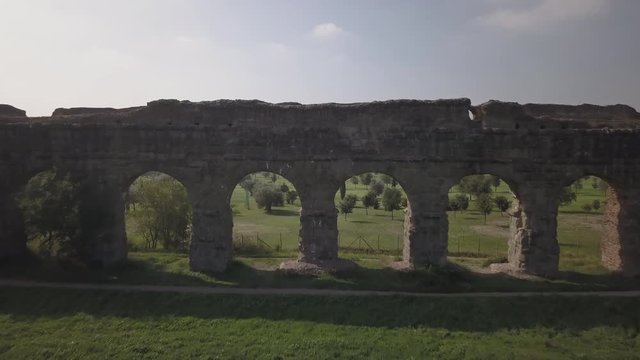 Video from above. Aerial view of the ancient Roman Aqueduct. Old ruins surrounded by a green public Park (Parco degli Acquedotti) Rome, Italy.	