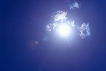 The sun on blue sky in the sunny day with lens flare effect.